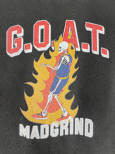 Load image into Gallery viewer, Zoomed front view of the GOAT CURRY TEE depicting a flaming skeleton with the letterings G.O.A.T and the brand name MADGRIND.