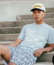 Load image into Gallery viewer, Our boy model sitting on the stairs wearing and representing our MG Lifestyle Summer Tees (Baby Blue) combined with Die or MG Hoop Shorts, MadGrind socks and MadGrind Curved Visor Snapback Hat.