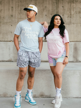 Load image into Gallery viewer, Our models standing featuring our girl model wearing and representing MG Lifestyle Summer Tees (Pink) combined with our Pastel Bandana Shorts and MadGrind socks then our boy model wearing and representing our MG Lifestyle Summer Tees (Baby Blue) combined with Die or MG Hoop Shorts, MadGrind socks and MadGrind Curved Visor Snapback Hat.