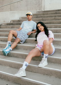 Our models sitting on the stairs featuring our girl model wearing and representing MG Lifestyle Summer Tees (Pink) combined with our Pastel Bandana Shorts and MadGrind socks then our boy model wearing and representing our MG Lifestyle Summer Tees (Baby Blue) combined with Die or MG Hoop Shorts, MadGrind socks and MadGrind Curved Visor Snapback Hat.