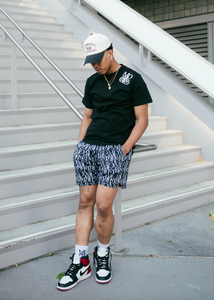 Our boy model wearing and representing our Monogram Logo Tee Black combined with our Monogram Pattern Shorts (Black) including the MADGRIND iconic socks and one of our MG hats snapback.