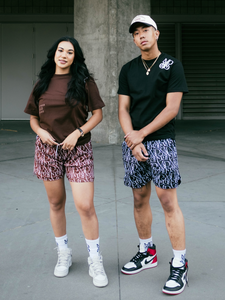 Our girl model wearing and representing our Monogram Logo Tee (Brown) combined with our Monogram Pattern Shorts (Brown) and our boy model wearing Monogram Logo Tee (Black), Monogram Pattern Shorts (Black) and our unreleased snapback hat.